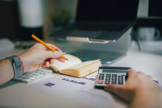 Persona calculando un presupuesto en su libreta