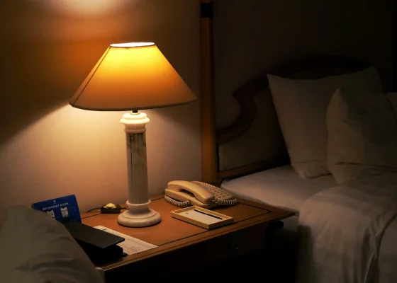 Lámpara encendida junto a una cama por la noche